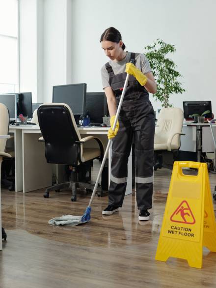 young-female-cleaner-in-workwear-using-mop-while-c--utc